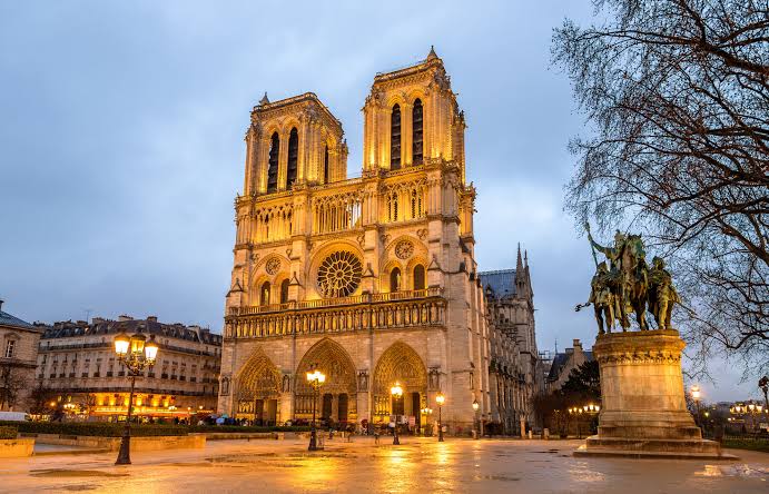 Façade de Notre-Dame de Paris illuminée à la tombée de la nuit
